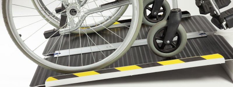 Wheelchair going up a folding wheelchair ramp to improve Accessibility