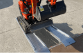 Pair of aluminium loading ramps with digger driving up 