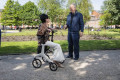 Lady sitting on four wheeled rollator in park 