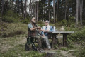 Rollator being used as a seat in woodland 