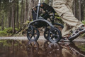 All terrain rollator being used in woodland through a puddle 