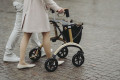 Lady pushing carbon rollator 