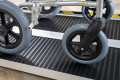 Manual wheelchair going up a wheelchair ramp with a black antislip surface 