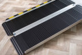 Black antislip wheelchair ramp resting on a step 