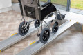 Wheelchair going up aluminium telescopic ramps 