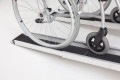 Wheelchair going up telescopic channel ramps 