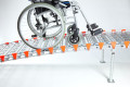 Wheelchair on long wheelchair ramp with support legs 