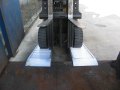 Forklift going up aluminium container ramps 