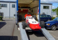 Car driving down loading ramps 