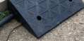 Channels running underneath rubber kerb ramp 