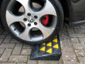 Car driving up kerb ramp 