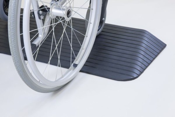 Wheelchair going up threshold ramp 