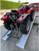 Tractor driving up vehicle ramps onto van 