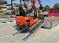 Tractor driving up vehicle ramps onto van 
