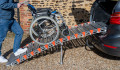 manual wheelchair being pushed up a rollable ramp into the boot of a car
