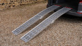 Pair of motorbike loading ramps resting on vehicle boot