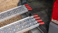 Pair of motorbike loading ramps resting on vehicle boot, close up of rest on connection