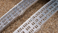 Pair of motorbike loading ramps resting on vehicle boot, close up of ramp surface