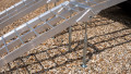 pair of motorbike ramps with support legs resting on the back of a vehicle, close up of support legs