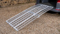 Full extra wide loading ramp kit set up and resting on the boot of a vehicle