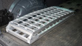 Single extra wide motorcycle ramp folded up and and stored in the boot of a car