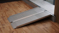 Folding wheelchair ramp resting on a step at home 