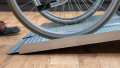 economy folding ramp resting on step with wheelchair being loaded. Safety edges, side view