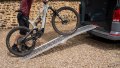 Motorbike loading ramp resting on vehicle boot with bike being loaded