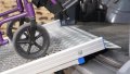 Loading manual wheelchair using a FEAL AnyRamp into a vehicle - showing close up of rest on connection
