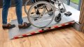 extra wide folding wheelchair ramp with red safety stripes, resting on a step with a manual wheelchair being pushed up