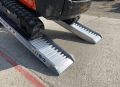 Digger driving up vehicle ramps 