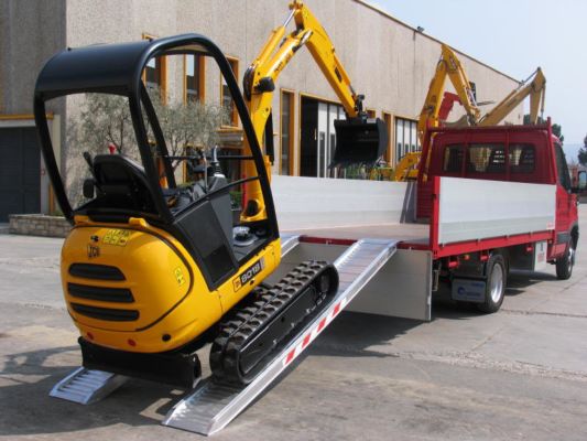 Mini digger loading ramps on truck 