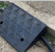 Black rubber kerb ramp with cables in channels 