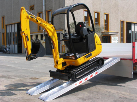 Mini digger unloading from truck 