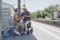 Rollator with seat in use as train station 