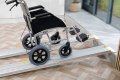 Wheelchair going up telescopic wheelchair ramps onto step 