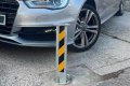 Telescopic bollard in place in front of car on driveway 