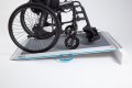 Non-folding wheelchair ramp with self propelled wheelchair going up the ramp 