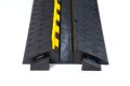 Open lid on the black and yellow rubber cable protector with antislip chequered surface 