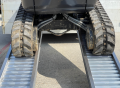 digger driving up ramps close up 