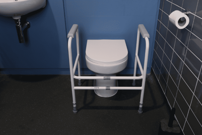 Adjustable toilet frame around a toilet in bathroom