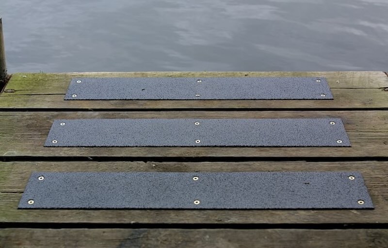 Black anti-slip strips on wooden decking walkway 