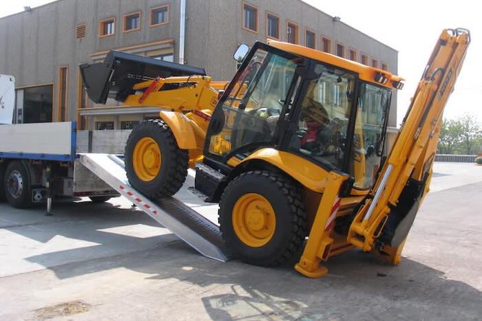 JCB driving up pair of aluminium loading ramps JCB driving up pair of aluminium loading ramps